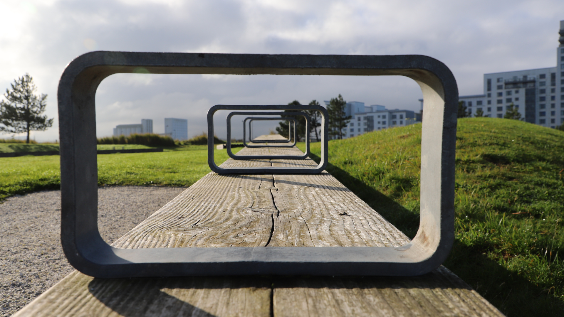 A line of identical frames receding into the distance along a wooden bench